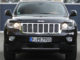 Ein schwarzer Jeep Grand Cherokee steht 2012 vor einer Villa.