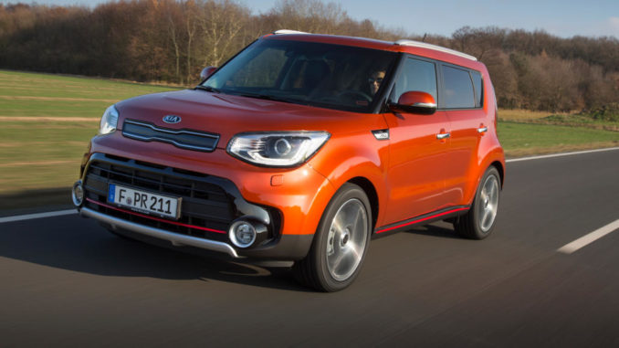 Ein rostroter Kia Soul fährt vor einer herbstlichen Landschaft.