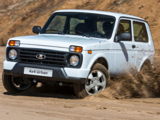 Ein weißer Lada 4x4 Urban fährt durch den Sand einer Kiesgrube.