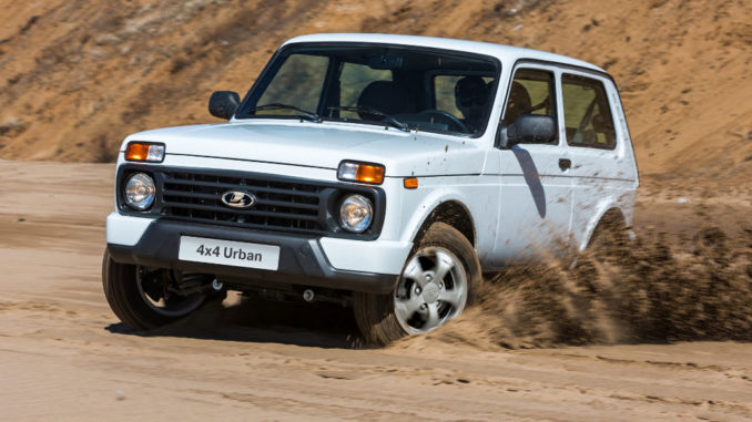 Ein weißer Lada 4x4 Urban fährt durch den Sand einer Kiesgrube.