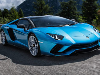 Ein blauer Lamborghini Aventador S Roadster fährt mit geschlossenem Dach auf einer Bergstraße.