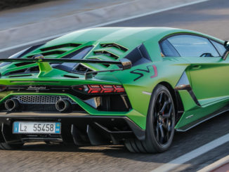 Ein grüner Lamborghini Aventador SVJ Coupé fährt auf einer Rennstrecke.