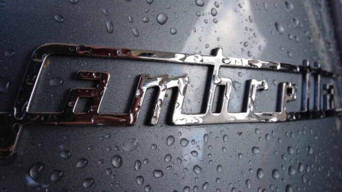 Verregnetes Lambretta-Logo auf metallicblauem Untergrund.