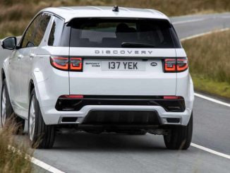 Ein Land Rover Discovery Sport PHEV in Fuji White fährt 2021 auf einer schottischen Hochlandstraße.