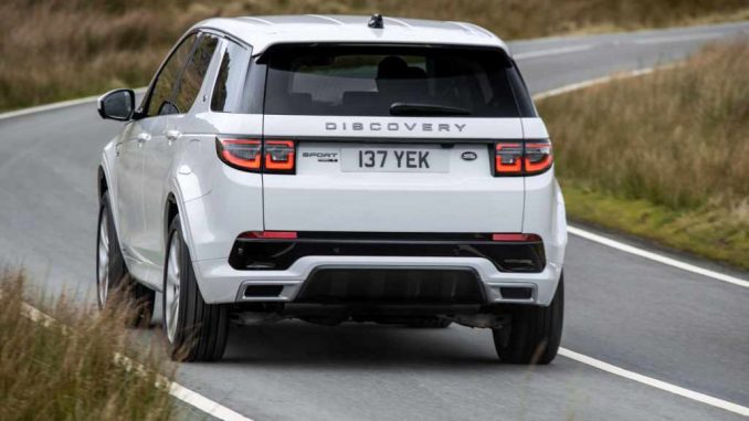 Ein Land Rover Discovery Sport PHEV in Fuji White fährt 2021 auf einer schottischen Hochlandstraße.