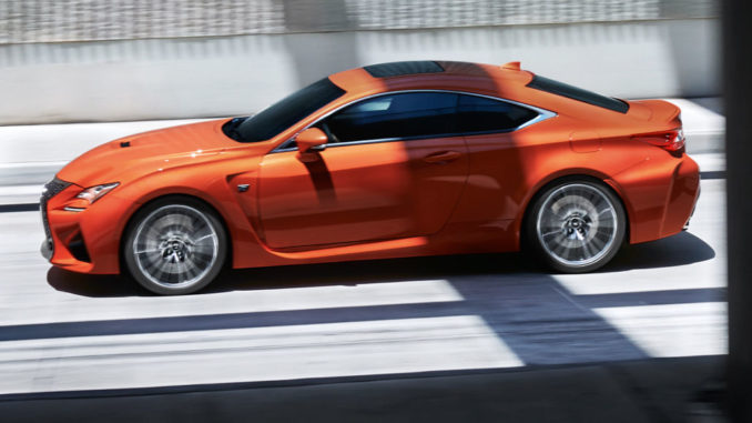 Ein orangener Lexus RC F fährt auf der Autobahn.