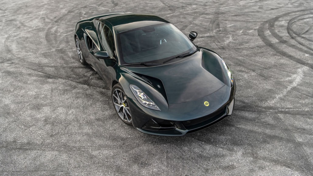 Ein schwarzer Lotus Emira steht 2022 auf einer Ausphaltfläche mit Reifenspuren.