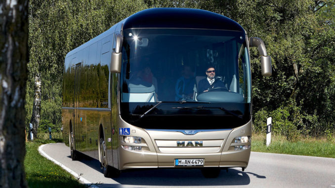 Ein goldfarbener MAN Lions Regio fährt auf einer Landstraße.