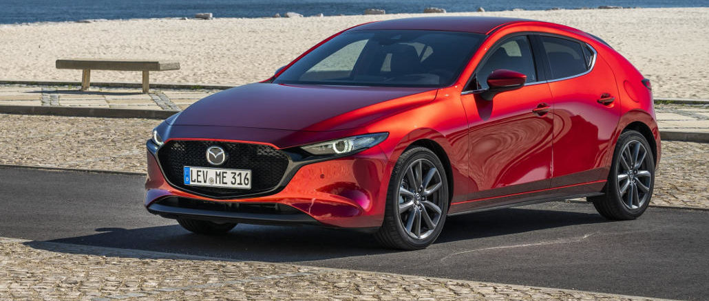 Ein roter Mazda3 (BP, MJ2019) steht an einem Strand.