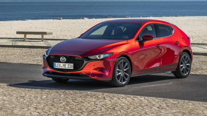 Ein roter Mazda3 (BP, MJ2019) steht an einem Strand.