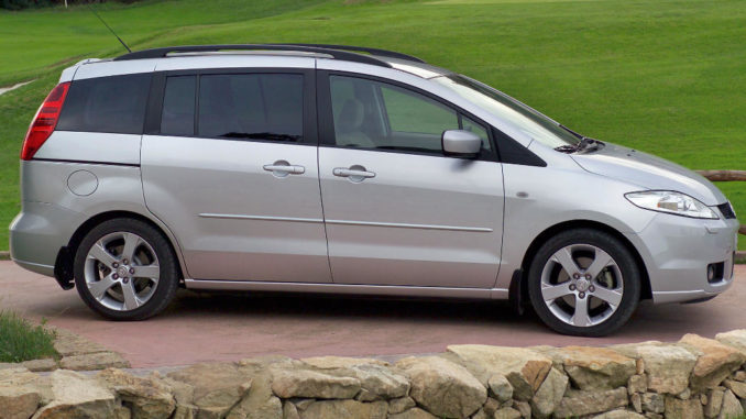 Ein silberner Mazda5 steht 2005 neben einem Golfplatz.