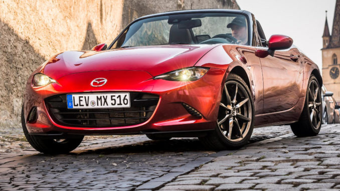 2019 MX-5 Transfagarasan Experience, roter Roadster steht auf abschüssiger Straße aus Kopfsteinpflaster.