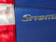 Heckleuchte und Schriftzug eines blauen Mercedes Sprinter des Baujahres 2011.