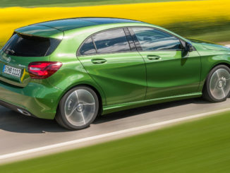 Mercedes-Benz A-Klasse (W176) 220d 4MATIC (Style), elbaitgrün, fährt 2015 an einem Rapsfeld vorbei.