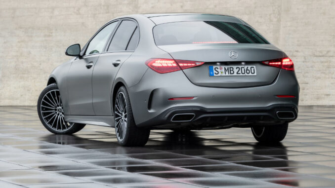 Eine Mercedes-Benz C-Klasse, 2021, Selenitgrau magno, steht auf einem regennassen Asphaltplatz.