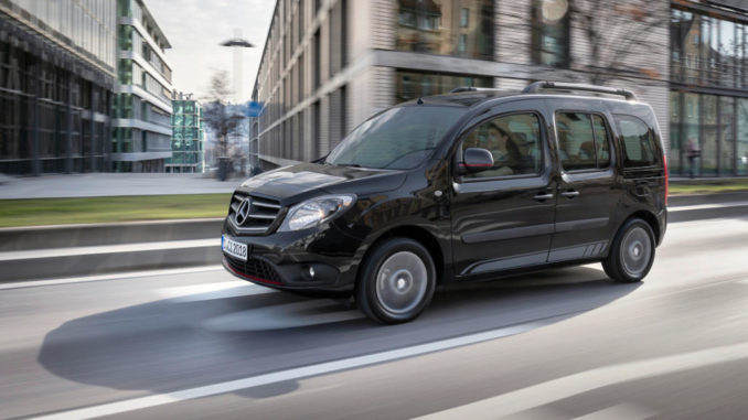 Ein schwarzer Mercedes-Benz Citan Tourer fährt 2019 an einem Bürogebäude vorbei.