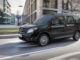 Ein schwarzer Mercedes-Benz Citan Tourer fährt 2019 an einem Bürogebäude vorbei.