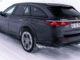 Ein schwarzer Mercedes-Benz E 300 de 4MATIC T-Modell All-Terrain mit EQ Hybrid Technologie fährt 2024 auf einer schneebedeckten Bergstraße.