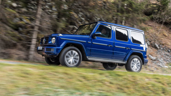 Ein Mercedes G 350 d; brilliantblau metallic, designo Leder Nappa espressobraun / schwarz, fährt im Dezember 2018 einen Waldweg bergauf.