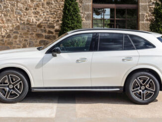 Ein Mercedes-Benz GLC 220 d 4MATIC, Exterieur: MANUFAKTUR diamantweiß bright, AMG Line; Interieur: Leder zweifarbig powerrot/schwarz, AMG Line, steht 2022 vor einem Haus in den Pyrenäen.