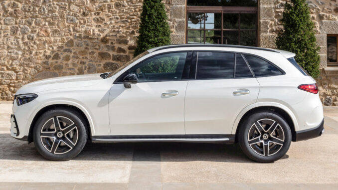 Ein Mercedes-Benz GLC 220 d 4MATIC, Exterieur: MANUFAKTUR diamantweiß bright, AMG Line; Interieur: Leder zweifarbig powerrot/schwarz, AMG Line, steht 2022 vor einem Haus in den Pyrenäen.