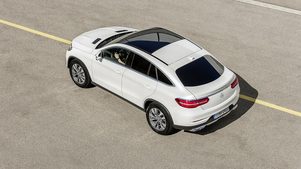 Ein Mercedes GLE 350 d Coupé 4MATIC, Exterieur: Designo Diamantweiß Bright, steht 2015 auf einem Parkplatz.