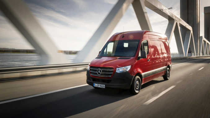 Ein roter Sprinter der Baureihe 907 oder 910 fährt 2018 über eine Autobahnbrücke.