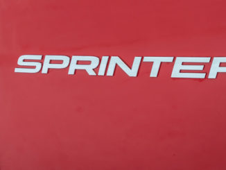 Schriftzug auf einem Mercedes-Benz Sprinter (Baureihe 907) – 319 CDI 4x4, 140kW (190 PS), Jupiterrot, Kastenwagen, aufgenomen 2018.