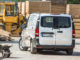 Ein silberner Mercedes Vito 116 CDI steht vor einem Holzstapel.