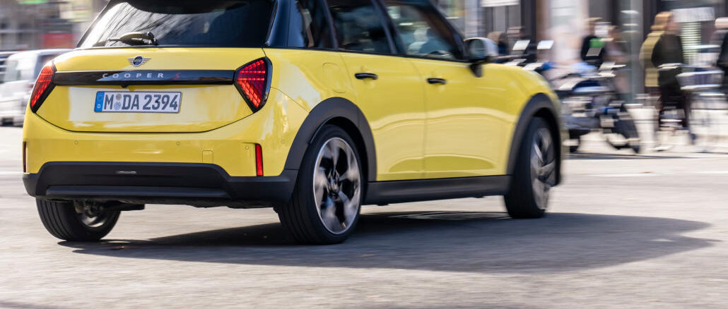 Ein gelber Mini Cooper fährt 2025 durch Barcelona.