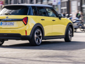 Ein gelber Mini Cooper fährt 2025 durch Barcelona.