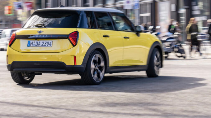 Ein gelber Mini Cooper fährt 2025 durch Barcelona.