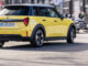 Ein gelber Mini Cooper fährt 2025 durch Barcelona.
