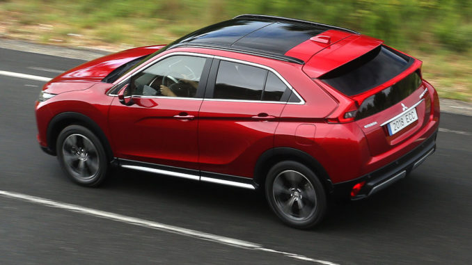 Ein roter Mitsubishi Eclipse Cross fährt auf einer Landtsraße.