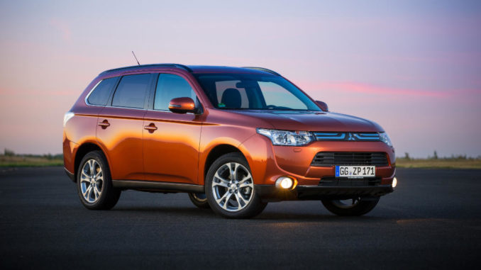 Ein rostroter Mitsubishi Outlander steht 2013 auf einer Teerfläche.