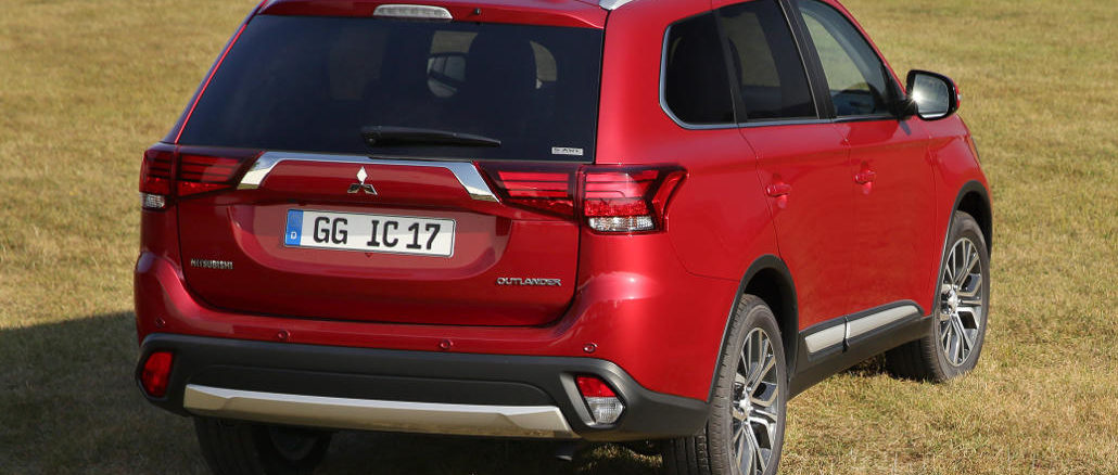 Ein roter Mitsubishi Outlander steht 2017 auf einer Wiese.