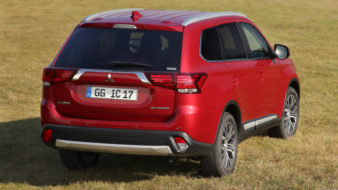 Ein roter Mitsubishi Outlander steht 2017 auf einer Wiese.