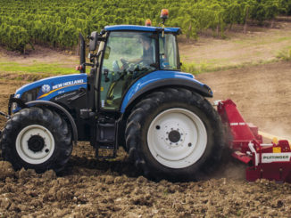 Ein blauer New Holland T5_115_ElectroCommand plügt einen Acker.