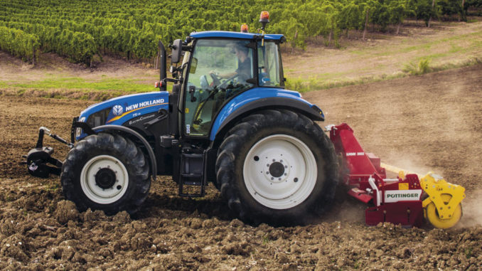 Ein blauer New Holland T5_115_ElectroCommand plügt einen Acker.