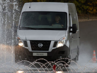 Ein silberner Nissan NV400 fährt bei einem Fahrsicherheitstraining über eine bewässerte Straße.