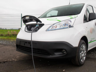 Ein weißer Nissan e-NV200 wird 2020 auf einem Betriebsgelände geladen.