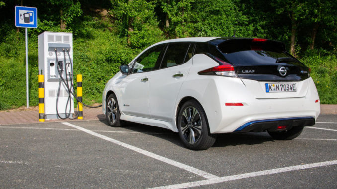 Ein weißer Nissan Leaf steht 2019 an einer öffentlichen Ladesäule für Elektroautos.