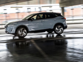 Ein grauer Nissan Qashqai E-Power fährt 2022 durch ein Parkhaus.