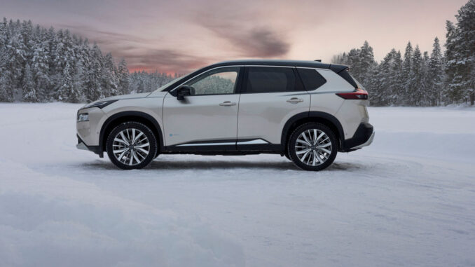 nissan_x_trai-_2024 Ein silberner Nissan X-Trail steht 2024 im Schnee.
