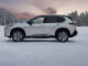 Ein silberner Nissan X-Trail steht 2024 im Schnee.
