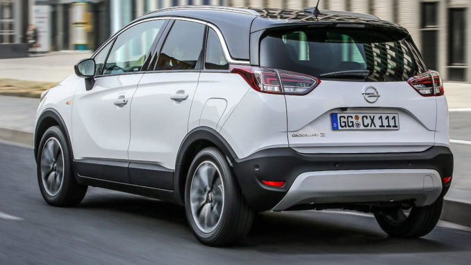 Ein weißer Opel Crossland X fährt durch die Straßen einer Stadt.