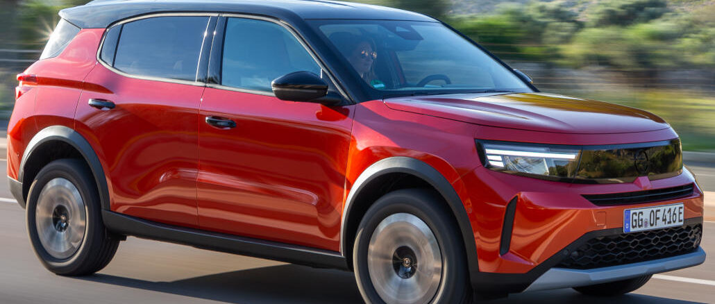 Ein roter Opel Frontera fährt 2025 über eine Landstraße.