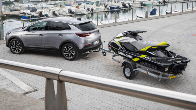Ein silberner Opel Grandland X steht 2019 in einem Hafen mit einem Jetski auf dem Anhänger.