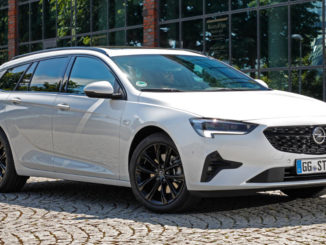 Ein weißer Opel Insignia Sports Tourer steht 2020 vor einer Glasfassade.