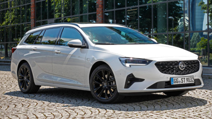 Ein weißer Opel Insignia Sports Tourer steht 2020 vor einer Glasfassade.